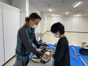 宮城電気サービスでの電気部品の説明を受けている写真
