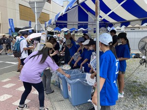 東松島夏まつりでごみの仕分けを補助している写真